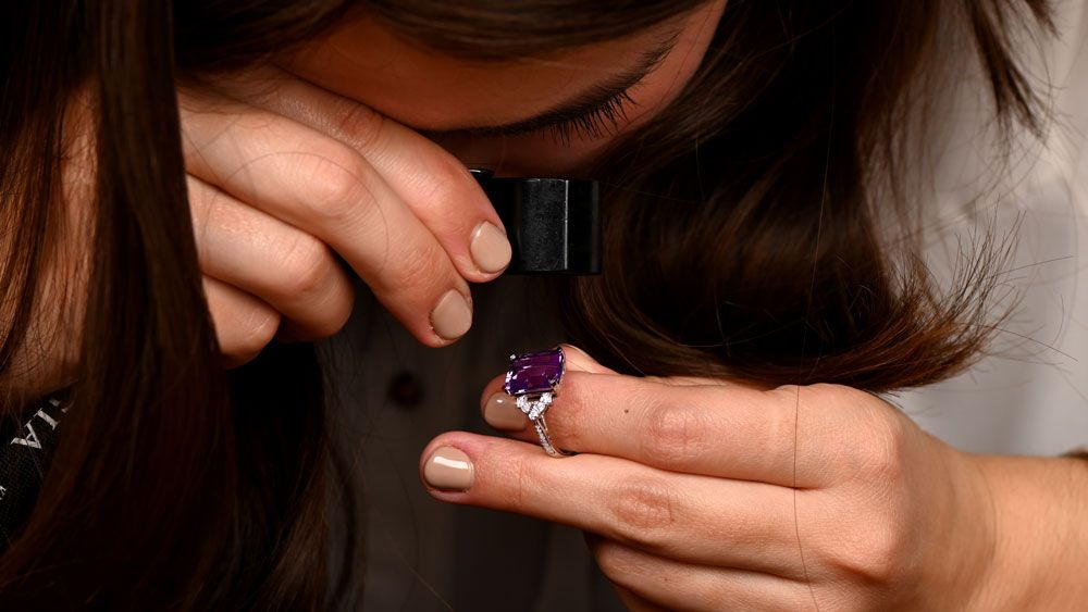 inspecting diamond ring with loupe