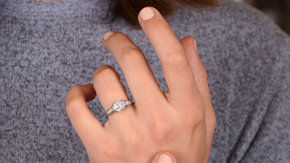 An Oval Engagement Ring On A Finger