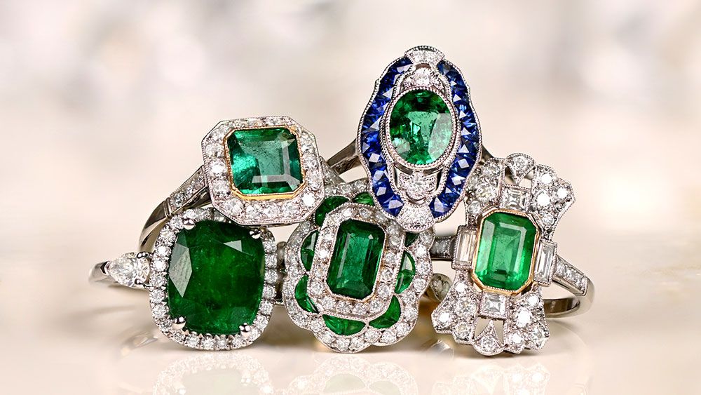 Group of Emerald Engagement Rings on Tile Surface