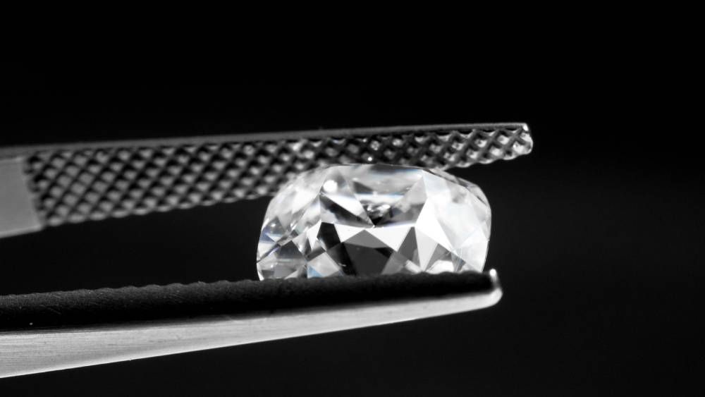 A Lab Grown Diamond Being Held By Tweezers