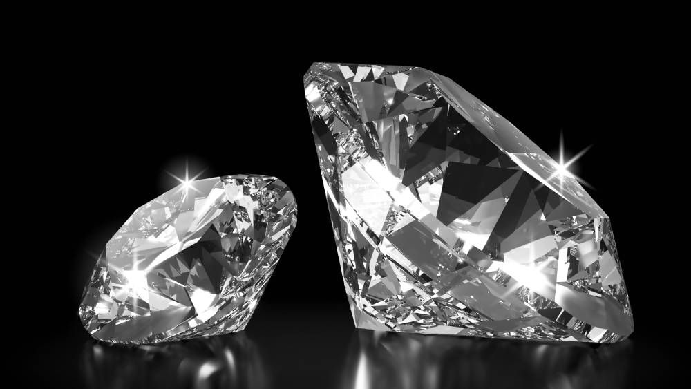 Two Diamonds Sitting Next To Each Other With Dark Background 