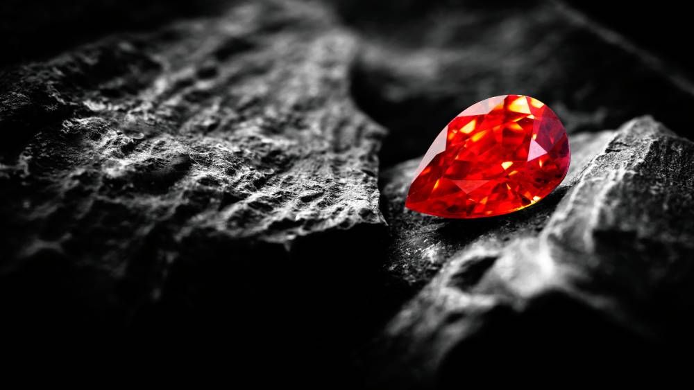 pear shaped red diamond on black rocks