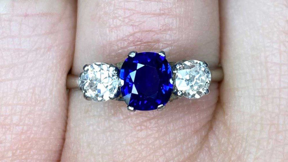 Three Stone Platinum Ring Featuring A Sapphire And Diamonds 